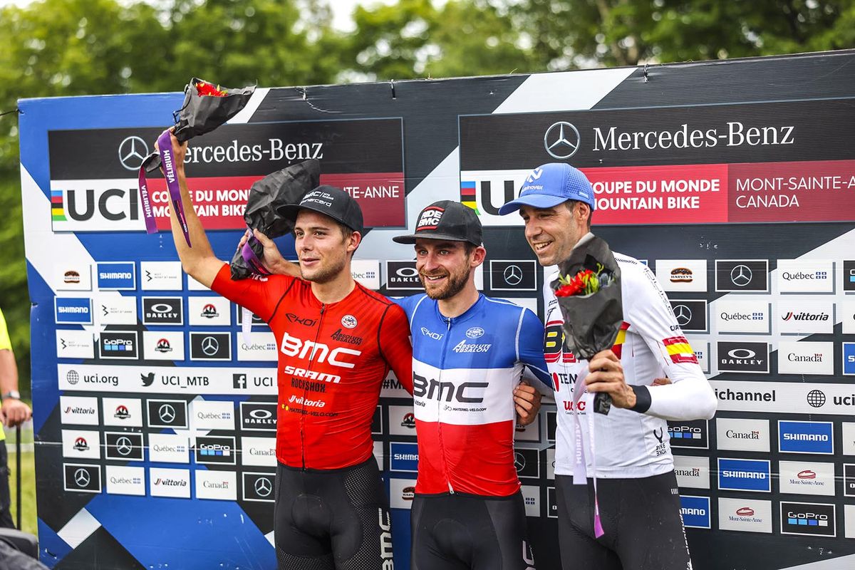 The elite men's XCO podium at the 2022 Mountain Bike World Cup in Mont-Ste-Anne, Canada: (L to R) Filippo Colombo (BMC MTB) in second, Titouan Carod (BMC MTB) in first and David Valero (BH Templo Cafes UCC) in third