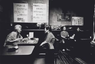 Black and white photo of Japanese people sitting in a coffee shop.