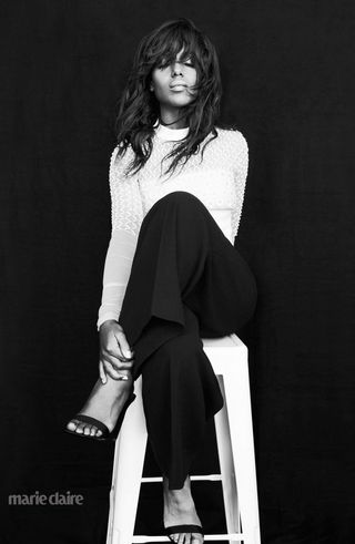 Kerry Washington sitting on a chair with legs crossed (black & white)