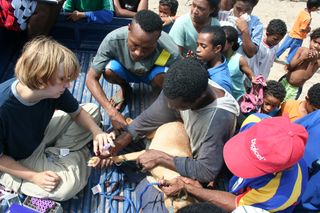 Taking a dog's blood in the back of a pick-up truck mobbed by interested Papuans. This type of scene was repeated across the world whenever we sampled in villages.