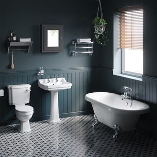 traditional bathroom suite with rolltop bath, deep blue panelled walls, and patterned flooring