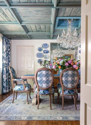 French country style dining room with wood panelled ceiling and blue and white chairs