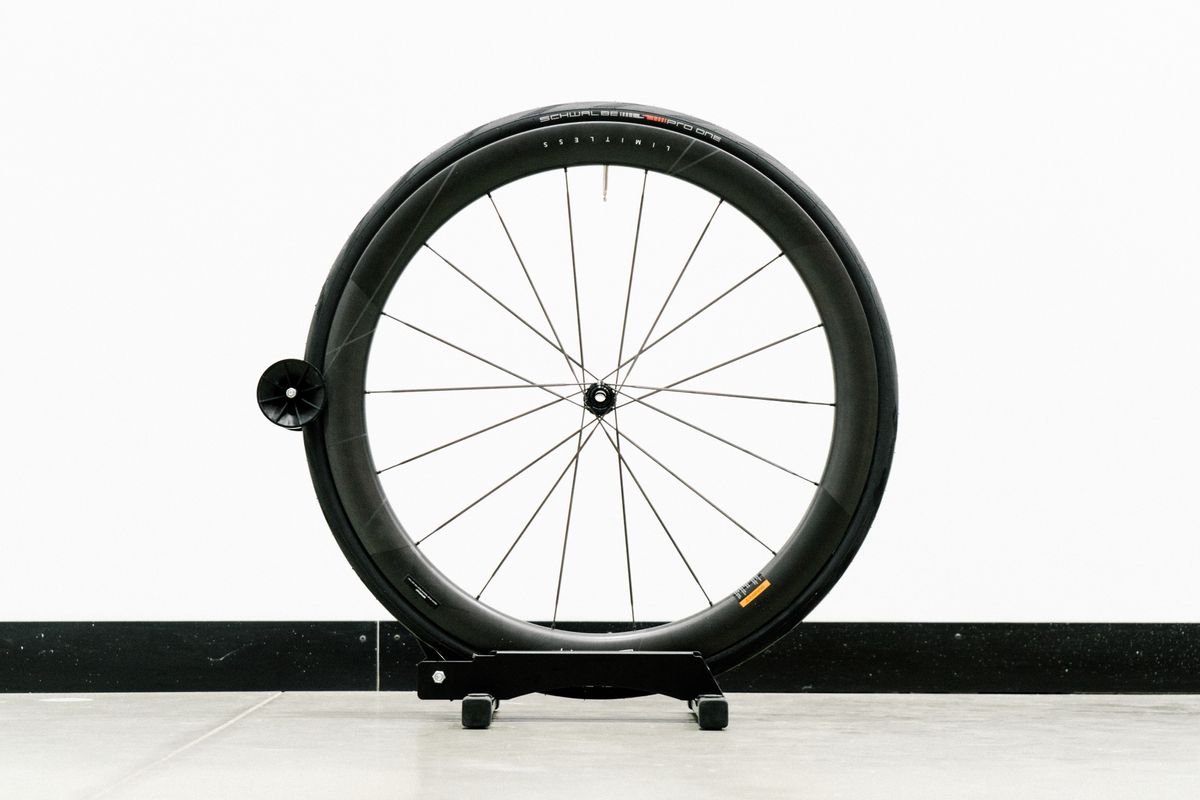 An aero road wheel stands against a white wall
