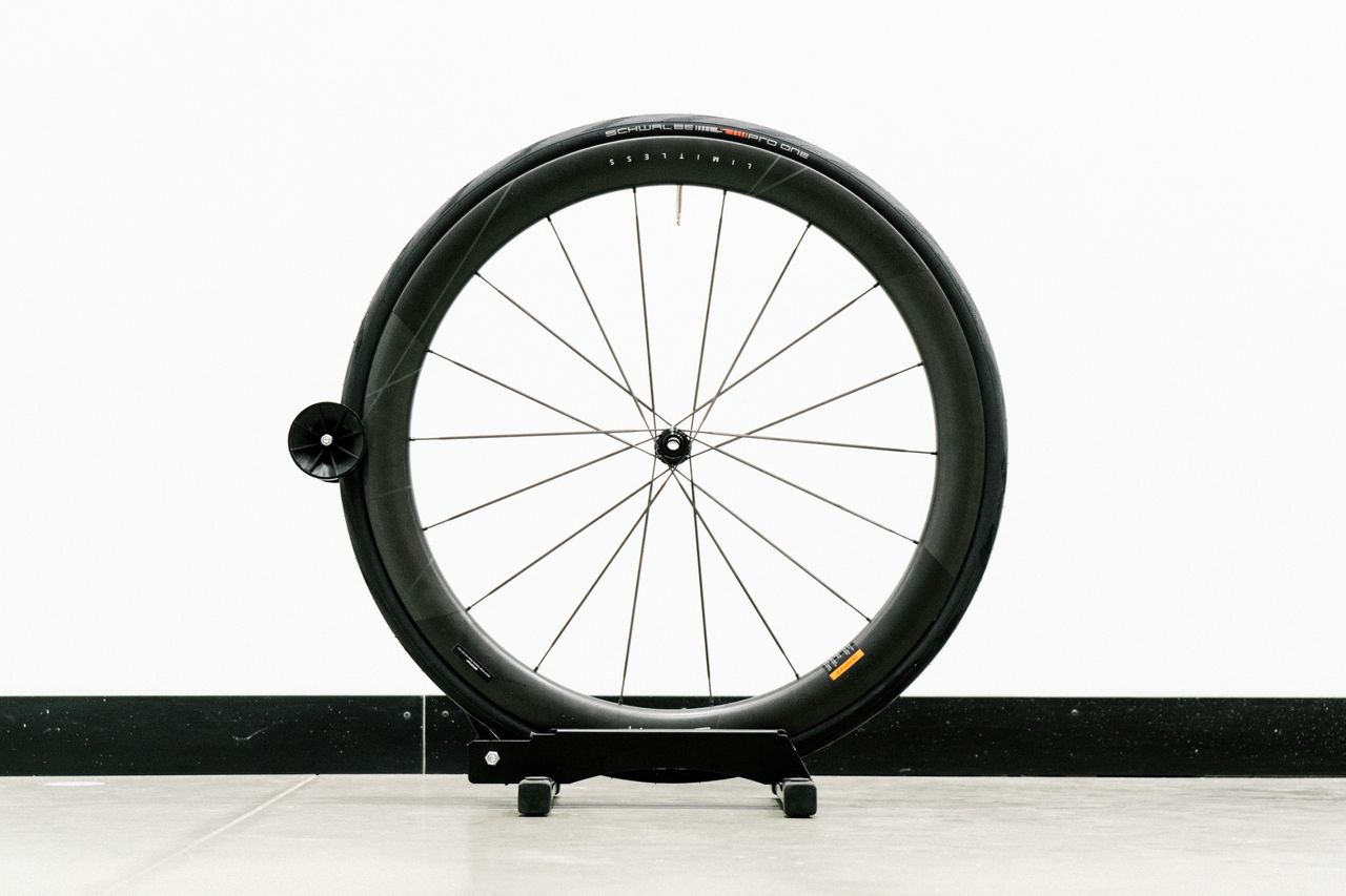 An aero road wheel stands against a white wall