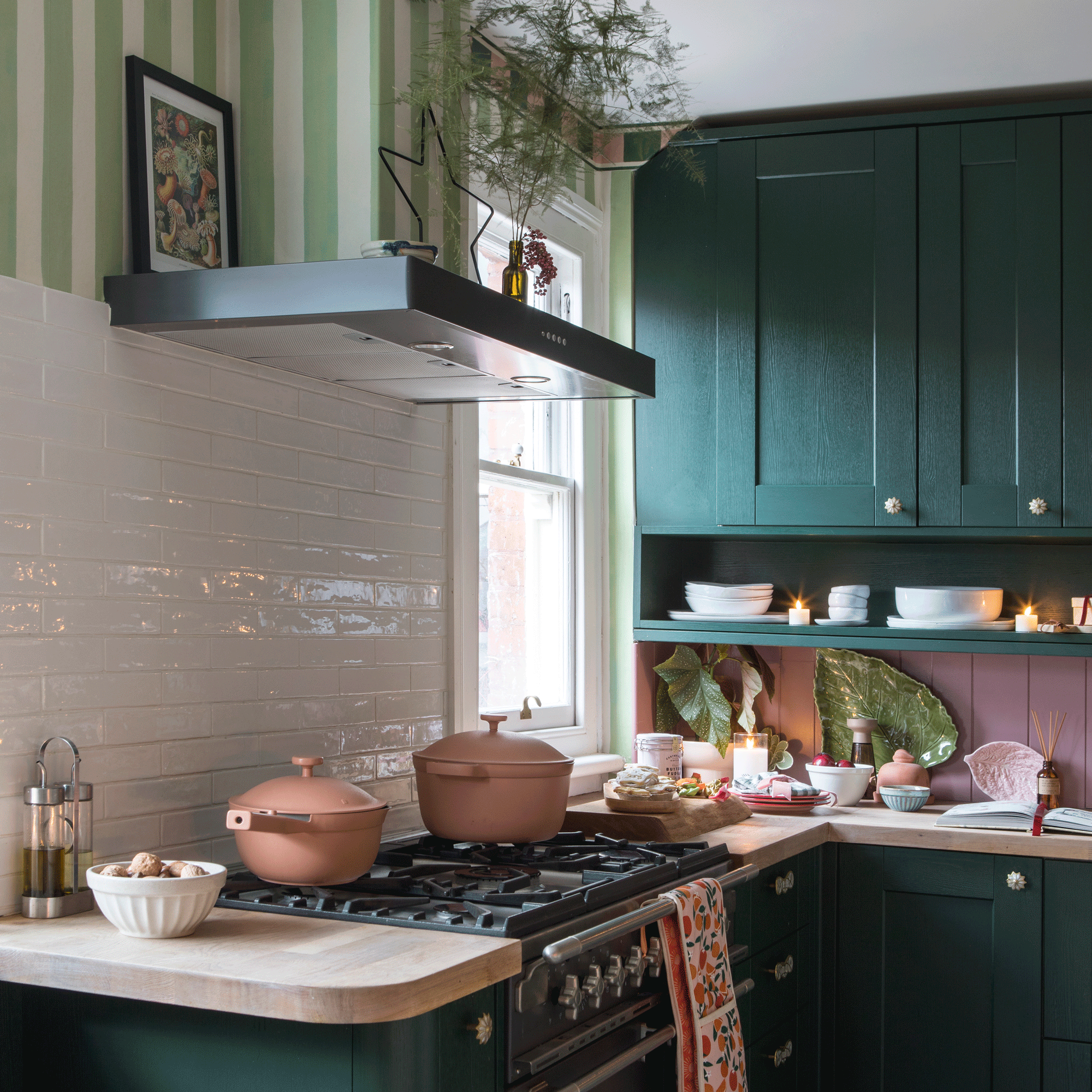a kitchen diner with green cabinetry, green and white striped wallpaper, a black range cooker 