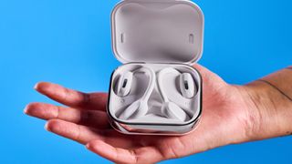 Tozo OpenEgo open-ear earbuds photographed in front of a blue background.