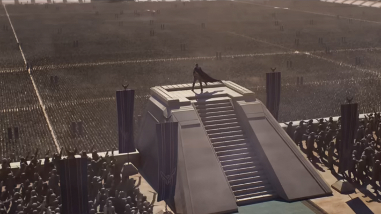 A person standing atop a pyramid in all black, looking over a huge crowd in Dune Part Three