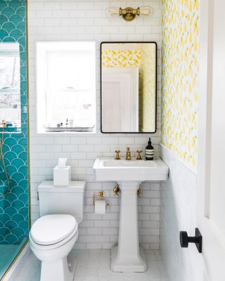 shower room with white subway tiles, blue fishscale tiles and yellow wallpaper
