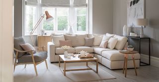 neutral living room color scheme with a cream corner soda and pale gray armchair to coordinate as an example of how to make a home look expensive