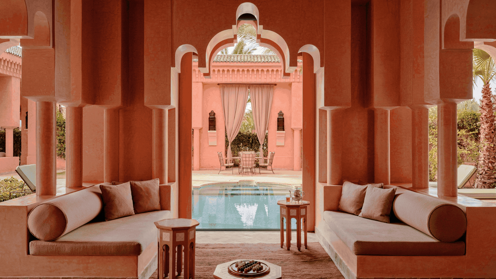 A rotating gif spotlighting a series of Morroccan interiors and exteriors characterized by vivid colors, arched walls and passageways, murals, and warm lighting.
