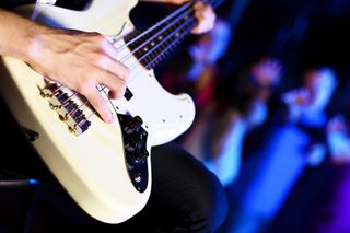 Young guitar player with instrument performing in night club