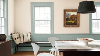 dining room with pale blue panelling, blue window frames and off-white walls