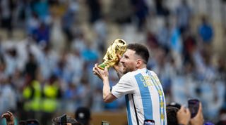 Lionel Messi of Argentina celebrates with the World Cup trophy after Argentina beat France in the final of the FIFA World Cup 2022 on 18 December, 2022 at the Lusail Iconic Stadium in Lusail, Qatar.