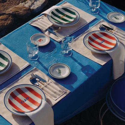 A set dining table with table linen and tableware with a Riviera theme from H&M Home's summer 2026 collection