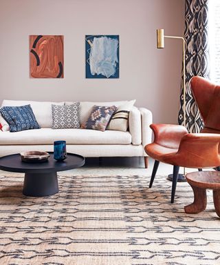living room with neutral rug, sofa and armchair