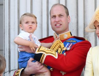 Prince Louis being held in the arms of dad Prince William on the royal balcony at Buckingham Palace during Trooping the Colour