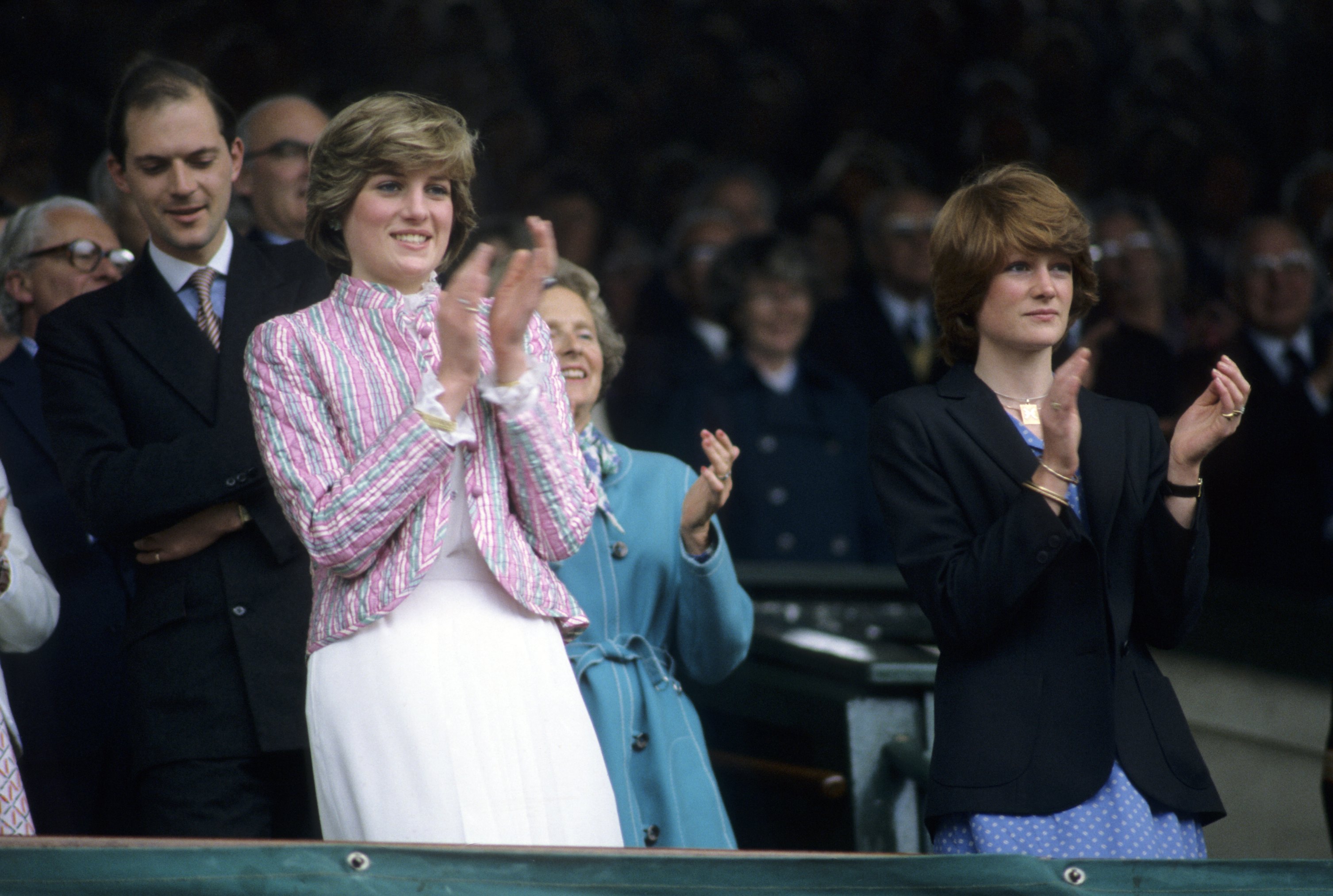 Princess Diana and her sister standing up clapping at Wimbledon