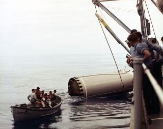 Sailors tow a segment of the Gemini-Titan 5 rocket's first stage to the U.S. Navy destroyer U.S.S. Du Pont to be brought back to shore.