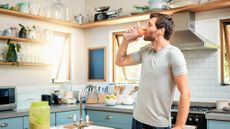 Man drinking a protein shake in the kitchen