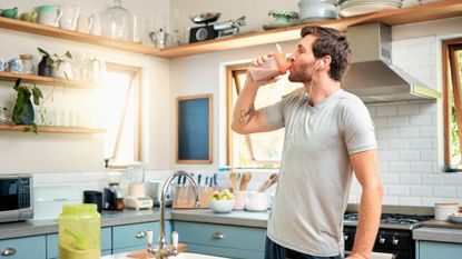 Man drinking a protein shake in the kitchen
