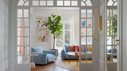 A light blue couch with wooden floor