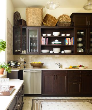 dark wooden kitchen with all wood cabinets, open shelving, vintage baskets along the top of the cabinetry and vintage mosaic tiles