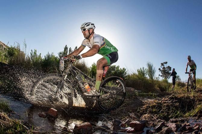 Riders make their way through farmlands and water crossings