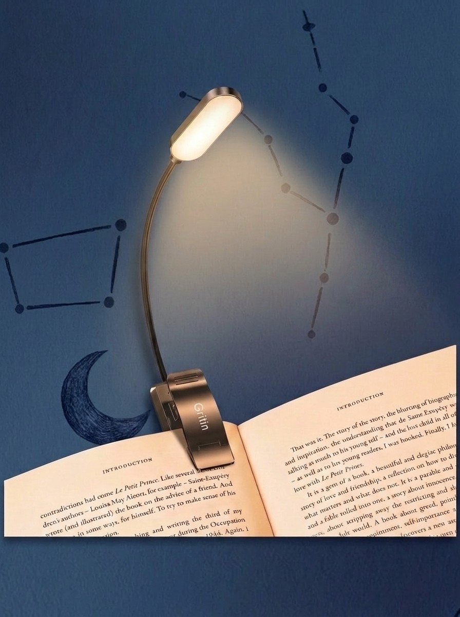 A Gritin book lamp clipped to a book against a blue background of stars, edited by Gemini