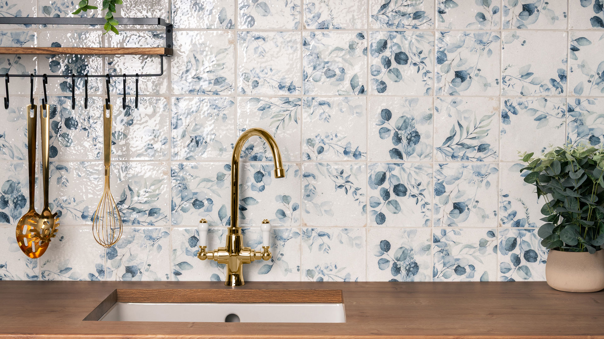 blue and white floral wall tiles in kitchen with brass tap
