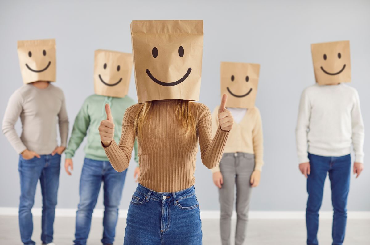 Several figures wearing paper bags on their heads with smiley faces drawn on them.