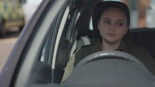 Jade sits along in her car with tears in her eyes
