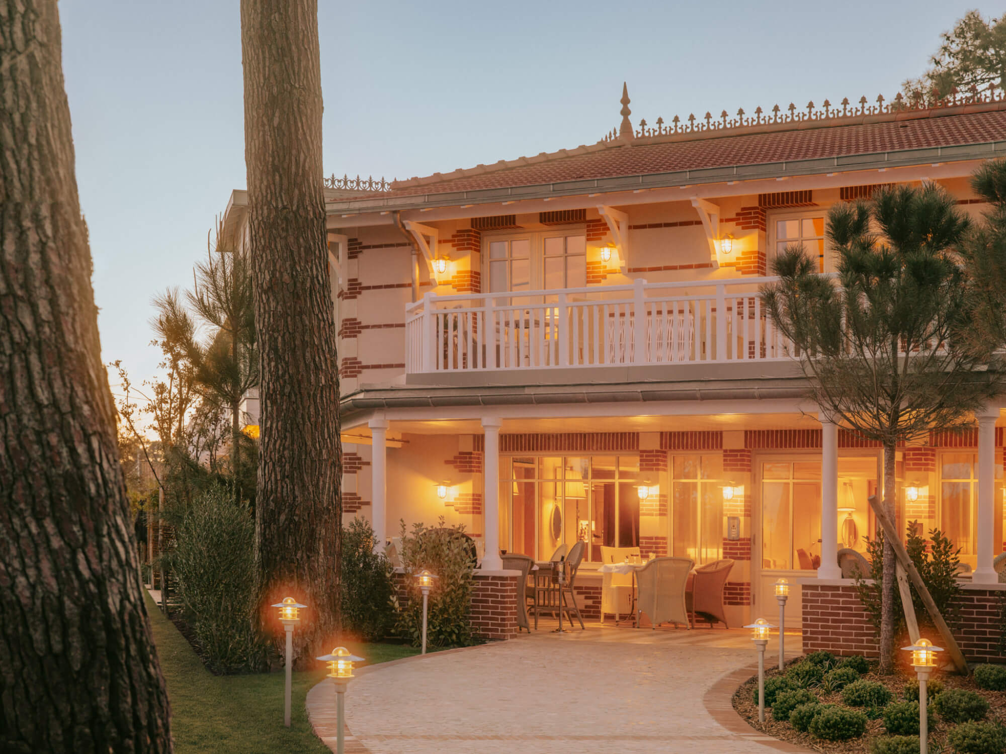 A white-washed coastal hotel boasts Mediterranean decor with minimal lines, occasional splashes of color, plenty of natural linens, plants, and wood accents, and sunshine throughout.