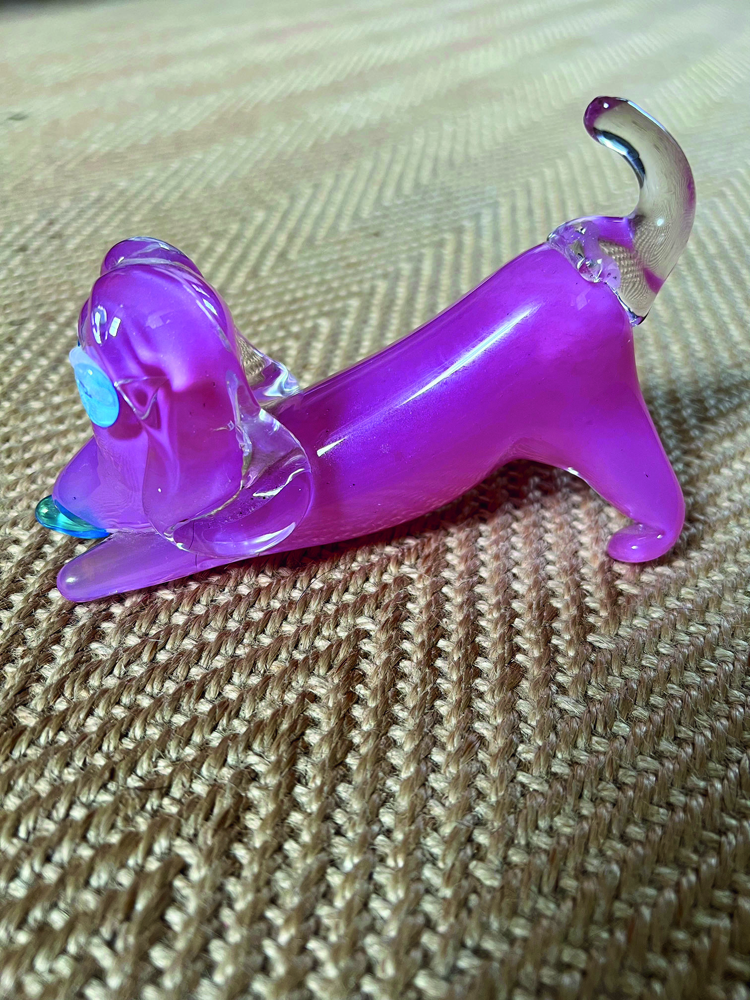 A small pink glass dachshund in a downward dog pose