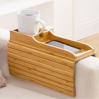 A bamboo couch holder on the arm of a chair