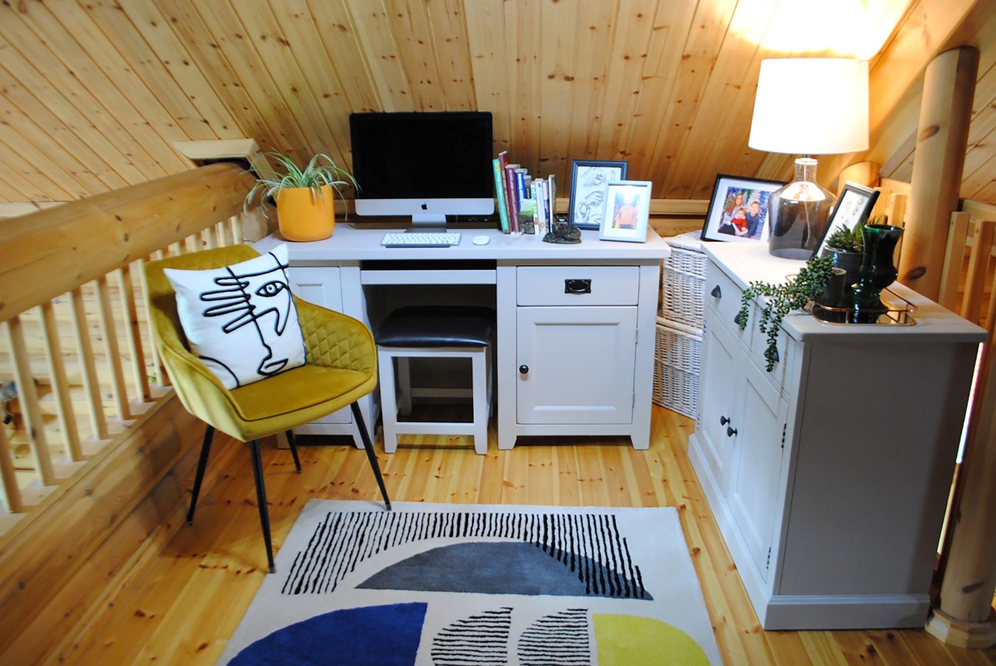 The office lies next to the staircase and lies against the sloped roof of the home