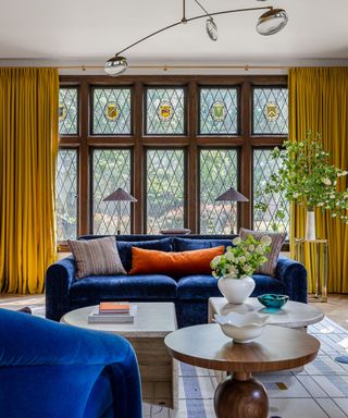 living room with dark blue sofa, mustard curtains and decorative items