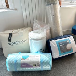 A selection of mattress toppers ready for testing in a bedroom