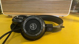 Grado SR80x headphones on yellow table in front of Ruark R2 radio