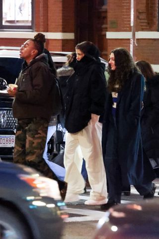 zendaya wears white track pants and a black puffer coat in boston