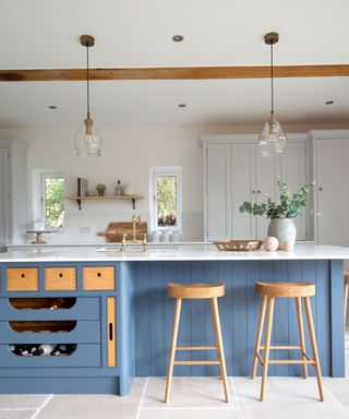 chalky blue kitchen island with wood bar stools and modern country feel