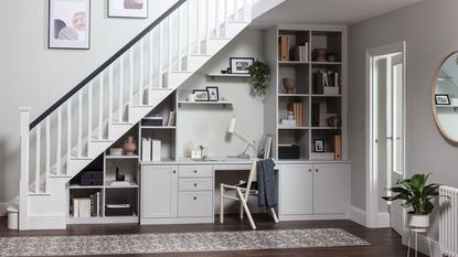 home office space under the stairs with bookcase and desk