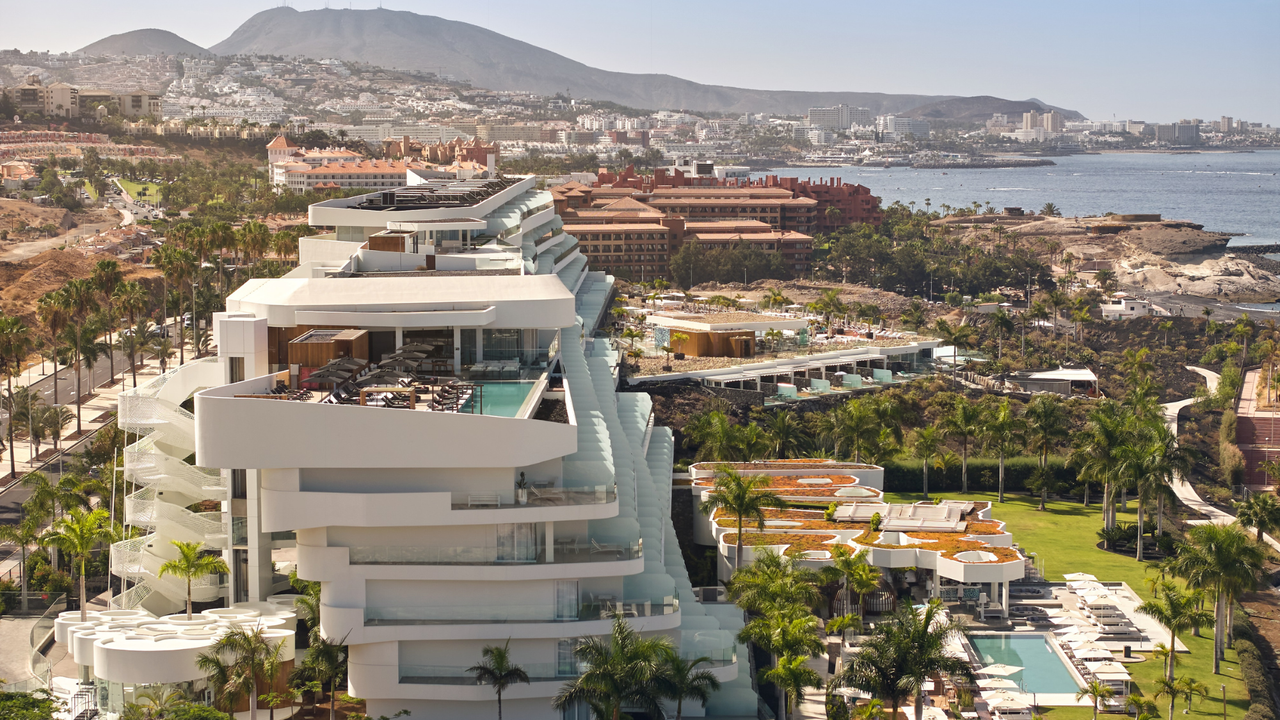 A view across Tenerife&#039;s coastline, with the striking white Royal Hideaway hotel in the foreground overlooking the sea