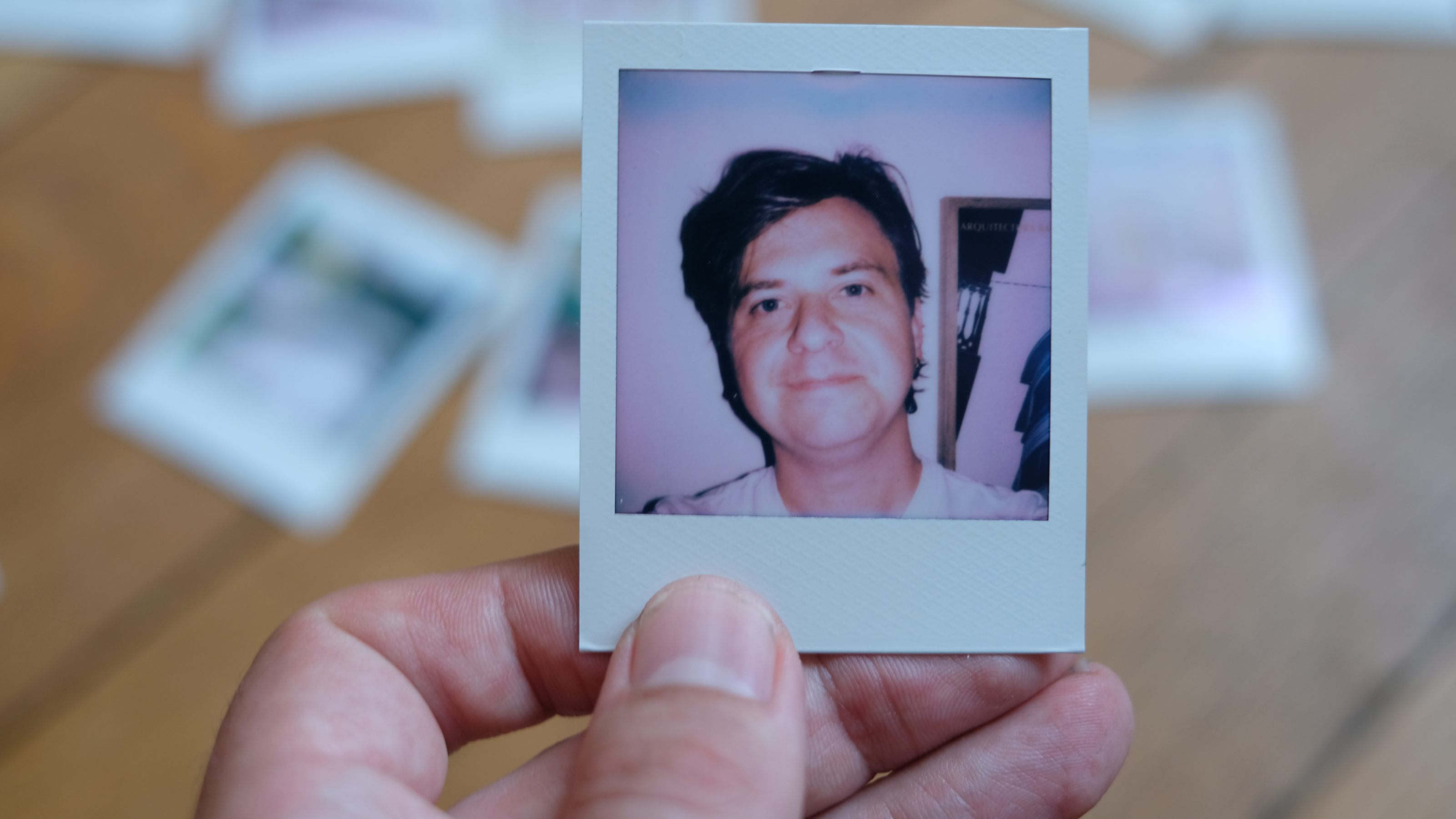 Photograph of prints made with Polaroid Go Gen 3, showing a selfie of a man lit with on-camera flash