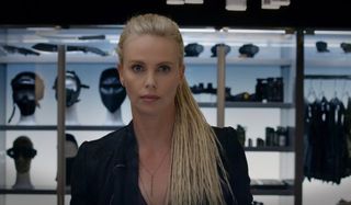 The Fate of the Furious Charlize Theron in front of an armor closet, with no emotion on her face