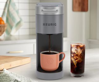 Keurig K Slim Coffee Maker on a countertop with an iced coffee beside it