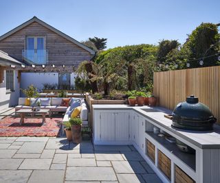 courtyard garden with a nuilt in outdoor kitchen area and seating area in the background