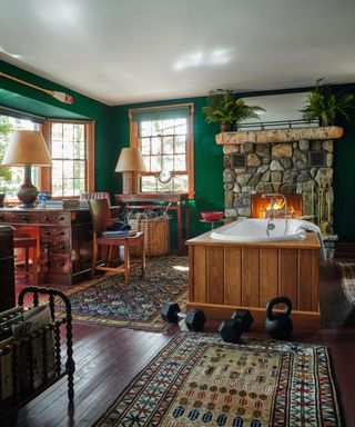 large bathroom with wood paneled bath surround and stone fireplace