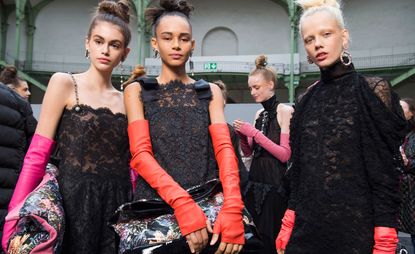 Chanel: Models are dressed in black lace dresses with colourful long gloves