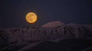 The full moon rises behind Monte Camicia mountain in Gran Sasso National Park in Italy, on Dec. 19, 2021.