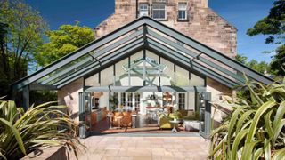 large kitchen conservatory on rear of stone house with extended canopy
